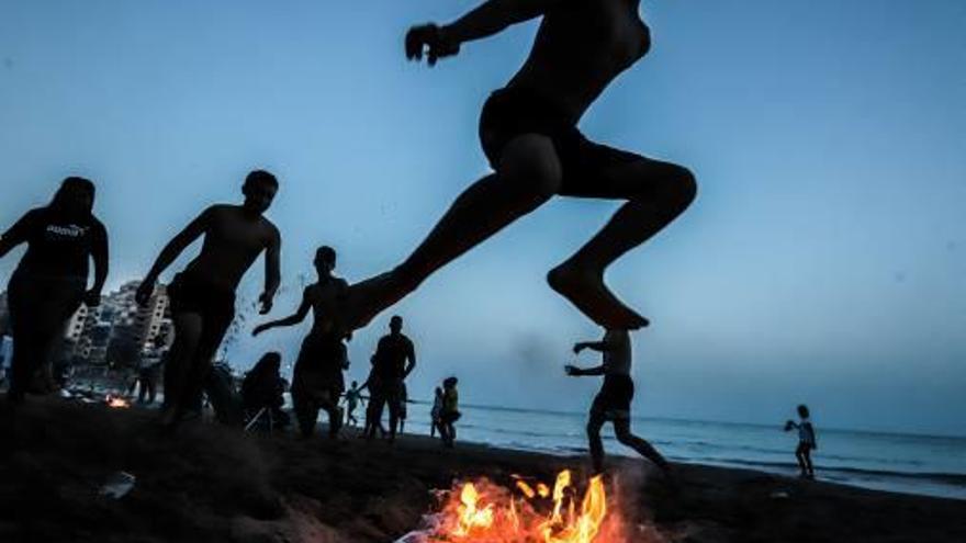 Saltos sobre hogueras en la noche del domingo en la playa de Cura.