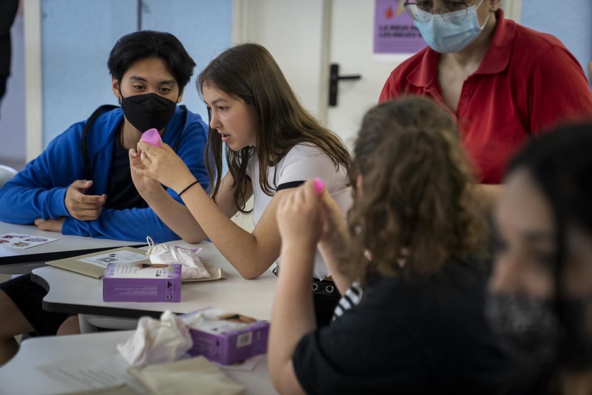 Alumnos del Institut Montjuïc examinan copas menstruales y otras alternativas sostenibles a compresas y tampones de un solo uso en el inicio del programa de educación menstrual 'La meva regla, les teves regles'.