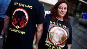 A relative of a victim wears a t-shirt reading Infected blood, died without justice as she stands outside Westminster, in central London, on May 20, 2024 during the Infected Blood Inquiry final report. A decades-long UK scandal in which thousands of people died after being treated with infected blood was covered up and largely could have been avoided, according to a bombshell report published on May 20, 2024. More than 30,000 people were infected with viruses such as HIV and hepatitis after being given contaminated blood in Britain between the 1970s and early 1990s, the Infected Blood Inquiry concluded. (Photo by BENJAMIN CREMEL / AFP)