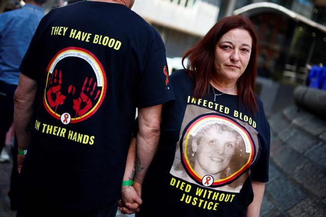 A relative of a victim wears a t-shirt reading Infected blood, died without justice as she stands outside Westminster, in central London, on May 20, 2024 during the Infected Blood Inquiry final report. A decades-long UK scandal in which thousands of people died after being treated with infected blood was covered up and largely could have been avoided, according to a bombshell report published on May 20, 2024. More than 30,000 people were infected with viruses such as HIV and hepatitis after being given contaminated blood in Britain between the 1970s and early 1990s, the Infected Blood Inquiry concluded. (Photo by BENJAMIN CREMEL / AFP)