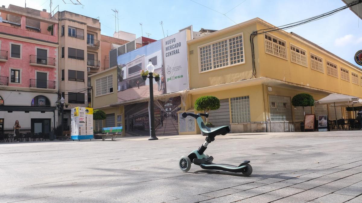 Un patinete delante del Mercado Central en la plaza de las Flores este mismo jueves.