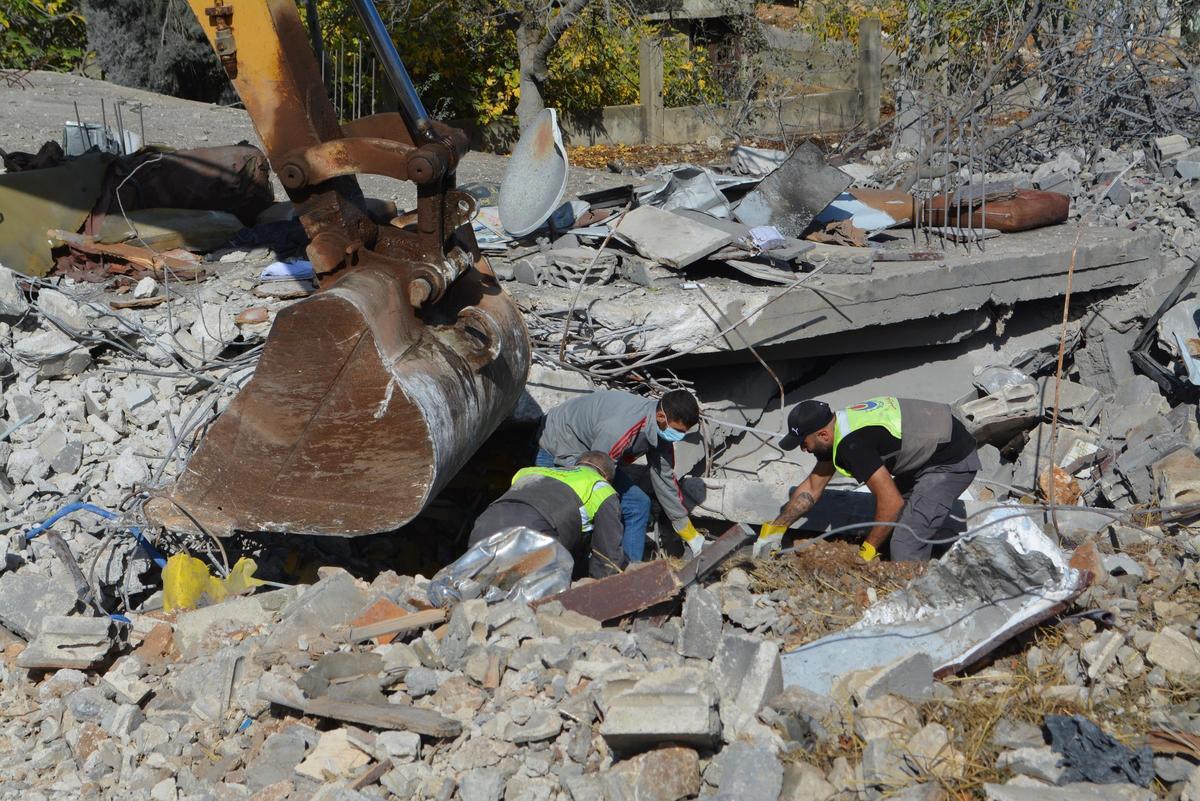 Miembros de la Defensa Civil libanesa retiran escombros de una vivienda derrumbada en un ataque israelí en Baalbek.