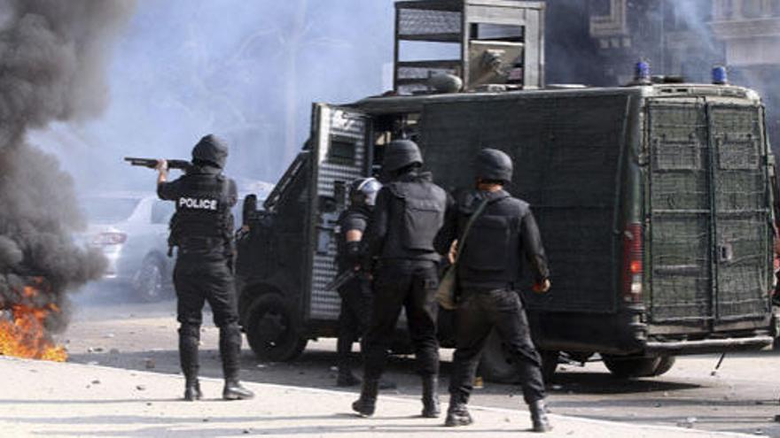 Policías antidisturbios disparan gas lacrimógeno.