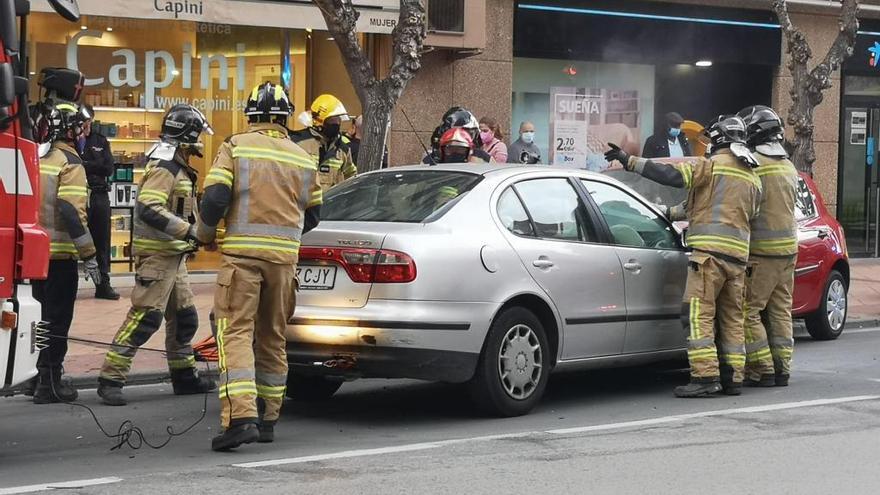 Bomberos rodean uno de los coches implicados.