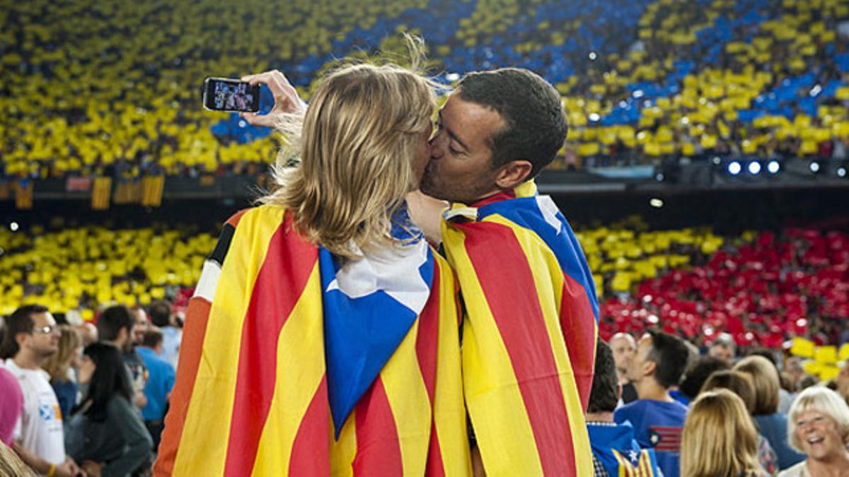 Una pareja con dos 'estelades' a modo de capa se besa en el Camp Nou