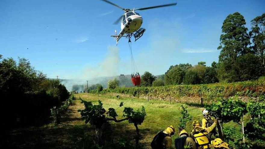 Un helicóptero participa en la extinción de un incendio en Bamio (Vilgarcía). // Iñaki Abella