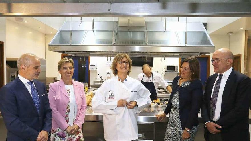 La ministra Tejerina, centro, se pone un uniforme de cocinero.