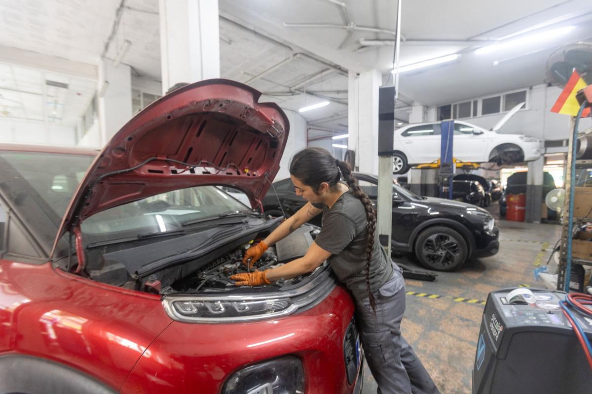 Una mecánica revisa uno de los coches en el taller de Alejandro Rico.