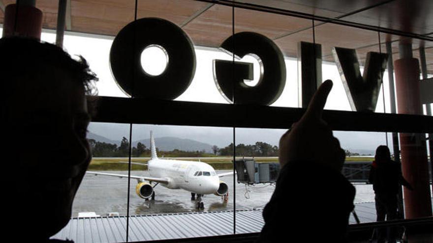 Varios pasajeros observan la llegada de un avión de Vueling a Peinador.