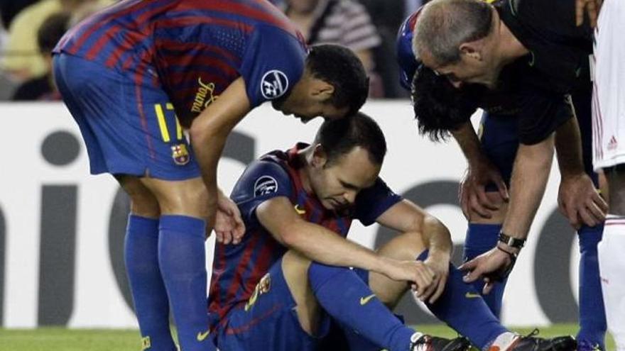 Iniesta, en el momento de lesionarse ante el Milan. / albert gea