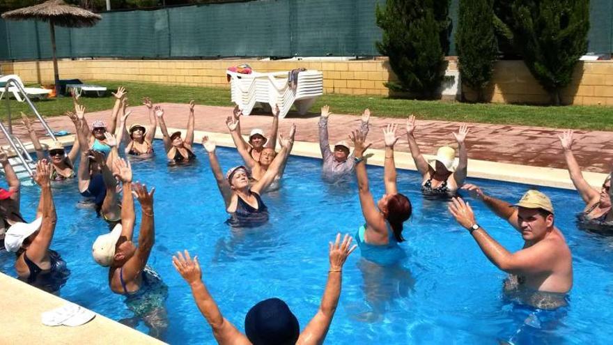 Personas mayores practicando aquagym en la piscina