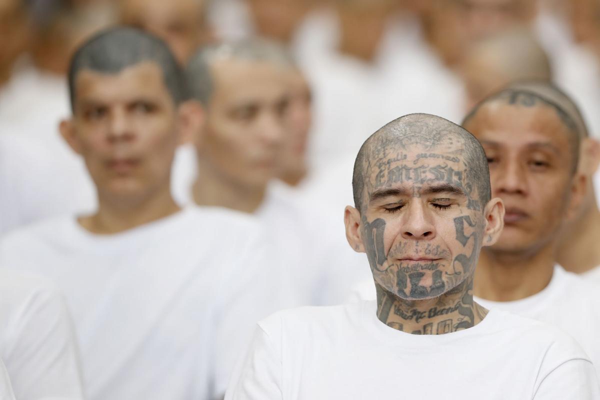 Un presunto integrante de la Mara Salvatrucha (MS13), recluido en el Centro de Confinamiento del Terrorismo (CECOT), reacciona en una audiencia virtual este jueves, en Tecoluca (El Salvador). Continúa, por cuarto día, la audiencia única abierta contra un grupo de más de 400 supuestos líderes de la MS13, que enfrentan, "por primera vez", en El Salvador un proceso penal bajo el modelo masivo por "47.000 delitos". EFE/ Rodrigo Sura