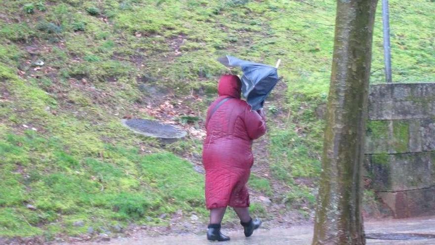 Una mujer se resguarda de la lluvia, ayer, en Santiago.