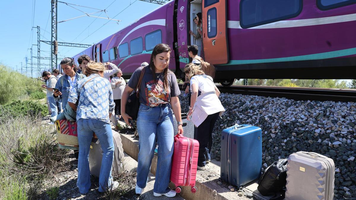 Varias personas bajan de un tren de Alta Velocidad parado por el apagón de luz.