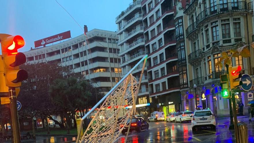 El temporal arranca unas luces de Navidad en Gijón