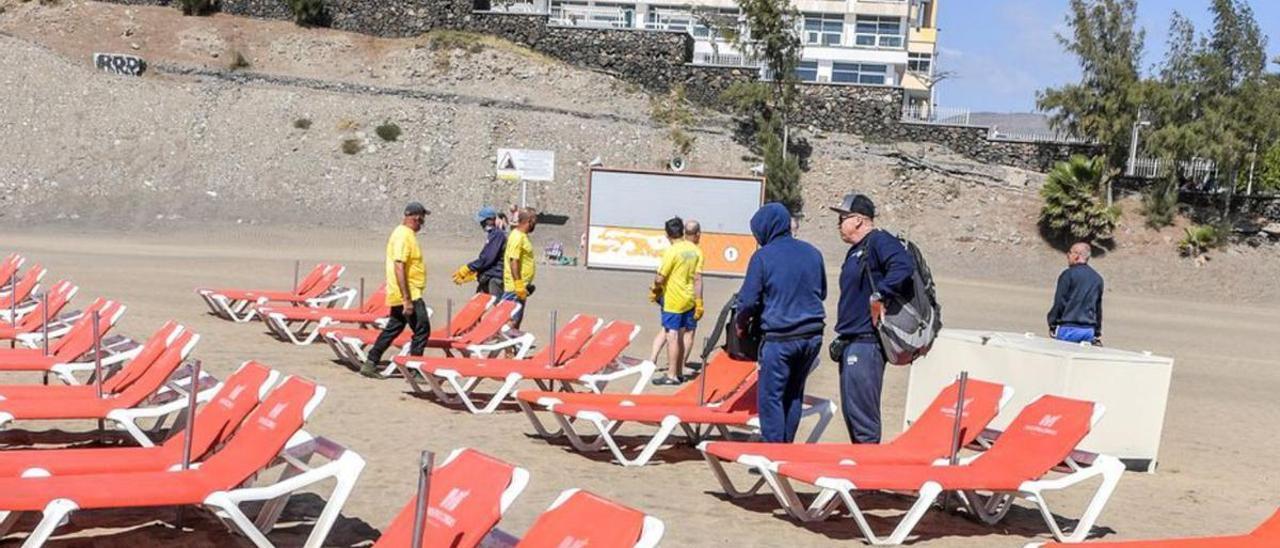 Colocación de hamacas en las Islas. Al fondo, un chiringuito cerrado.