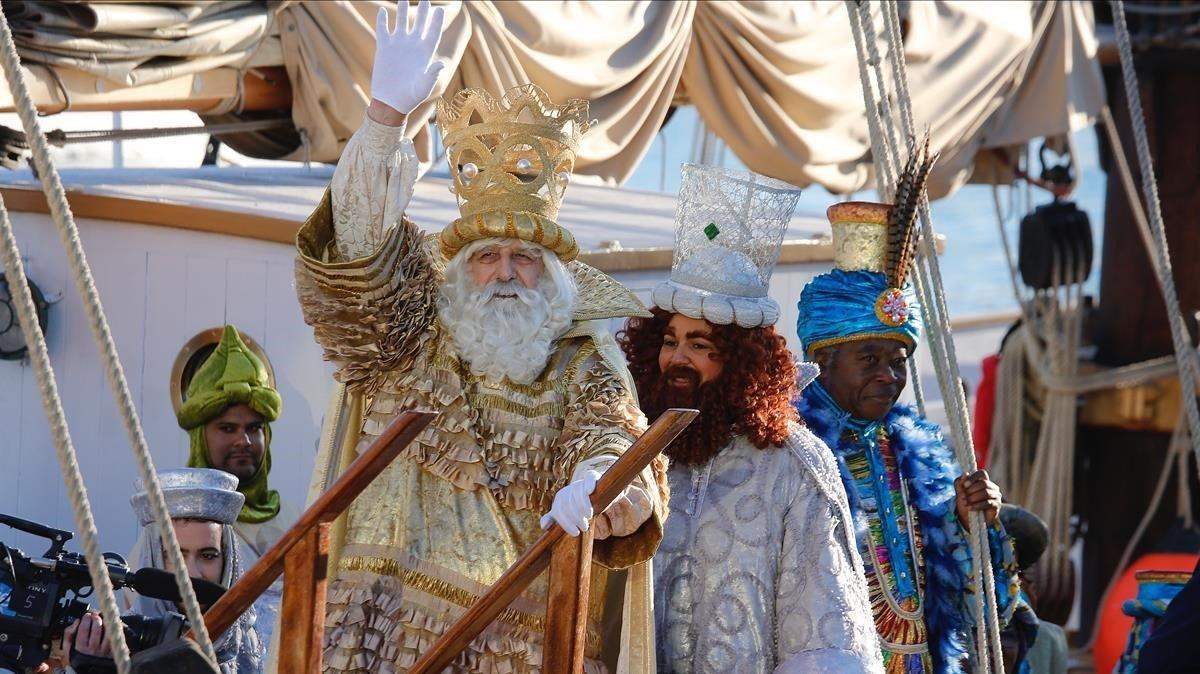 Los Reyes Magos saludan a la gente a su llegada a Barcelona, el año pasado.