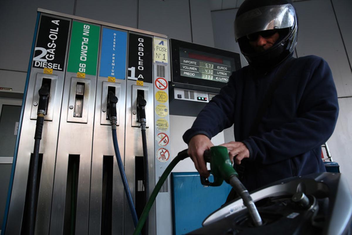 Un motorista posa combustible en una gasolinera de Barcelona.