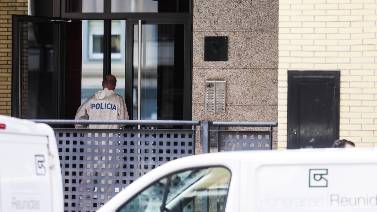 Agentes de la policía científica, en el portal del edificio donde residía la fallecida.