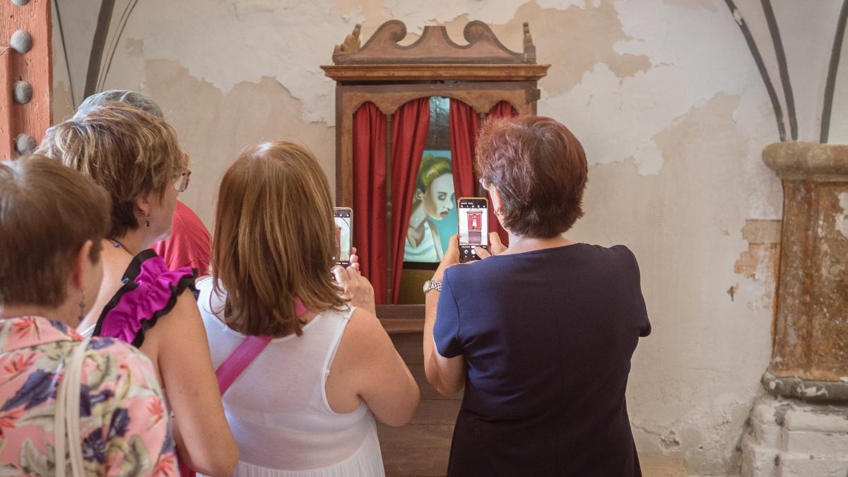 Varias mujeres de la localidad fotografían con el móvil una de las obras de Yann Leto en Arándiga.