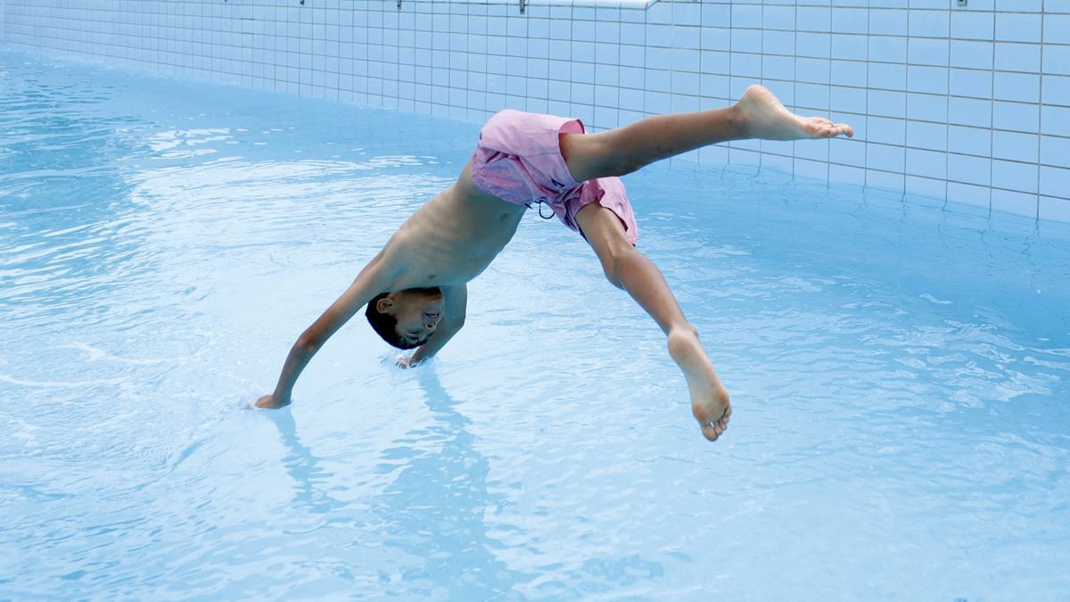 Un niño salta al agua en el primer día de piscinas municipales