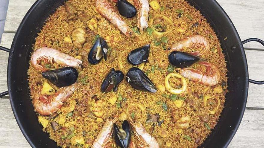 Alles drin in der „gemischten Paella&quot;: Gemüse, Reis, Meeresfrüchte, Hühnchen und Kaninchenfleisch, serviert in einer flachen Pfanne.