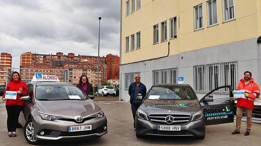 Responsables de Cruz Roja y voluntarios de las autoescuelas participantes posan con los vehículos que recorrerán la ciudad.