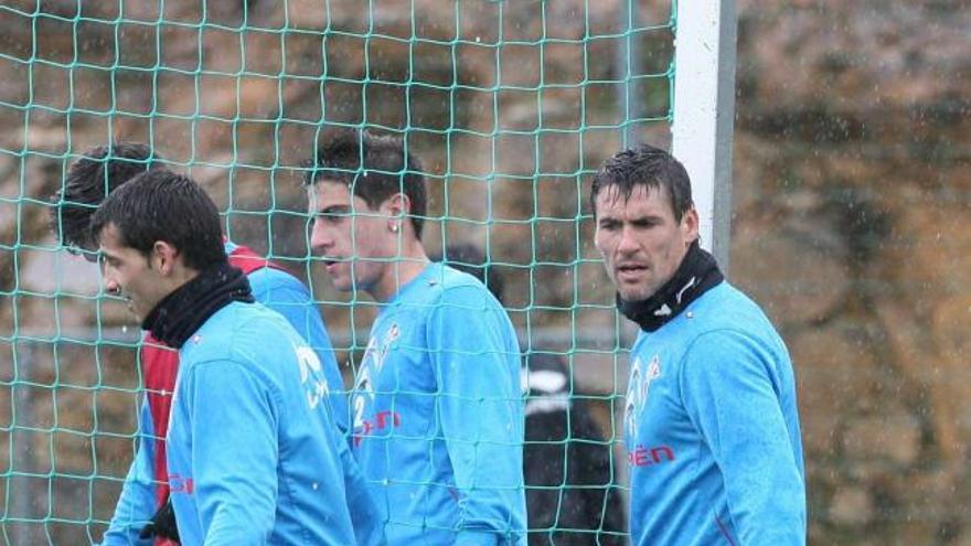 Bermejo carga con una portería, junto a Jony, a la izquierda, y el centrocampista      juvenil Borja Fernández (centro),  ayer en A Madroa. // De Arcos