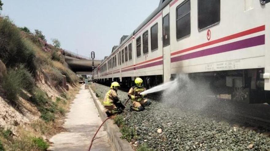 Tareas de extinción del fuego originado en un tren este domingo en Alicante.