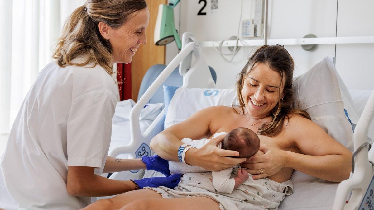 Una llevadora dona suport en la lactància a una mare a l'hospital Santa Caterina.