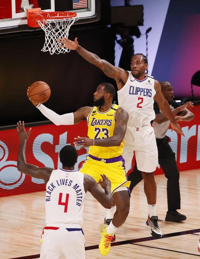 El alero de los Lakers de Los Ángeles, LeBron James (L) entra a canasta ante el alero de los Clippers de Los Ángeles Kawhi Leonard (R) en el segundo cuarto del partido de baloncesto de la NBA entre los Lakers de Los Ángeles y los Clippers de Los Ánge