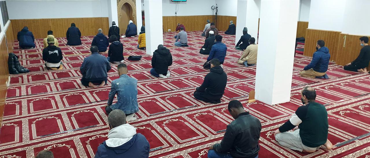 Varios hombres realizan la primera oración en la mezquita tras la puesta de sol.