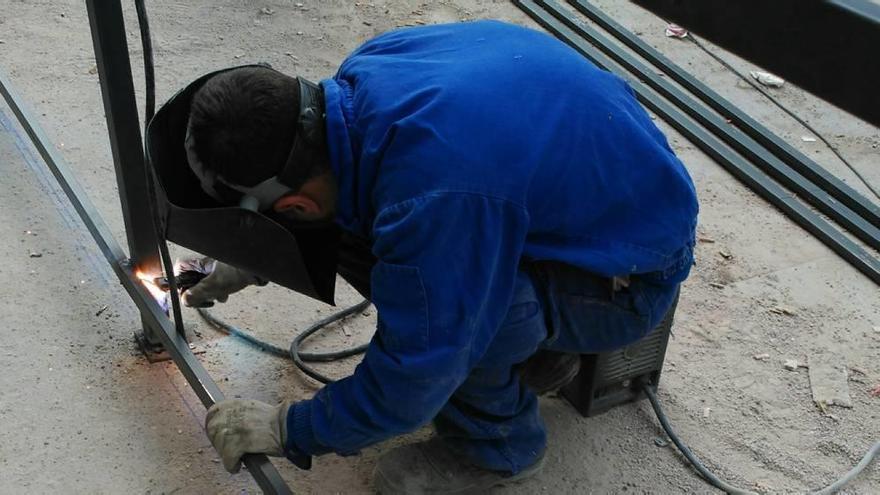 Un hombre que trabaja como autónomo realiza las labores de soldadura entre dos metales.