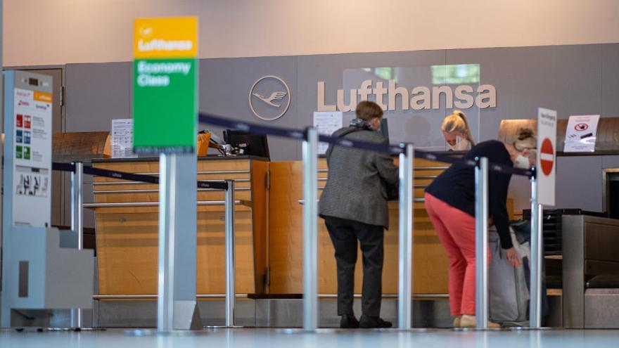 Varios clientes en un mostrador de Lufthansa en un aeropuerto.