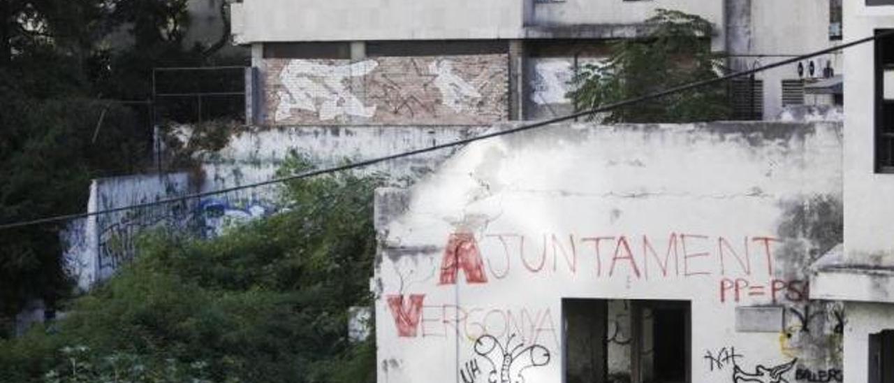 El muro de entrada a la antigua piscina municipal tiene pintadas contra los políticos.