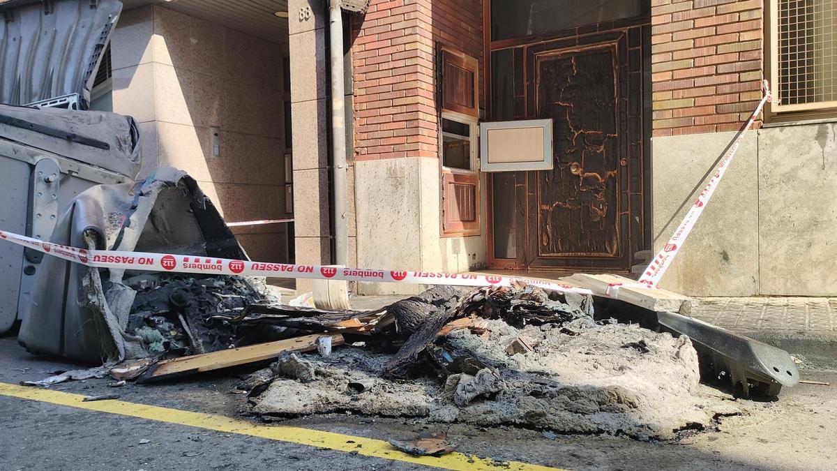 Les flames que han calcinat dos contenidors al carrer Major han cremat també la porta d'una casa