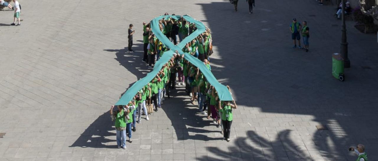 Pacientes y voluntarios de la AECC crean un lazo humano.