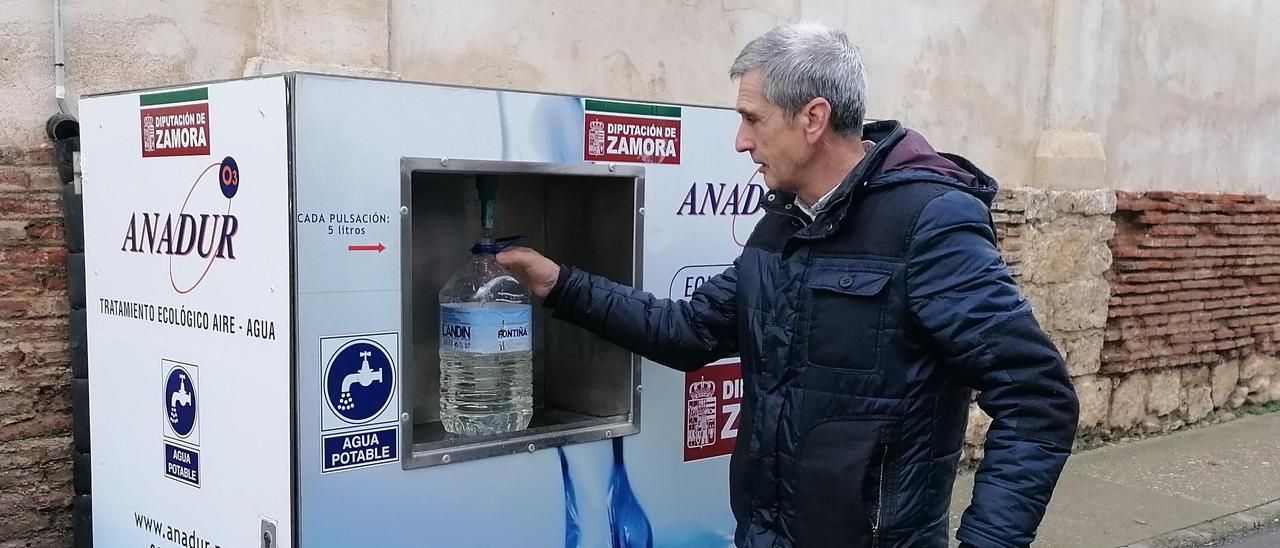 Un vecino llena una garrafa con agua en la planta potabilizadora instalada en San Francisco