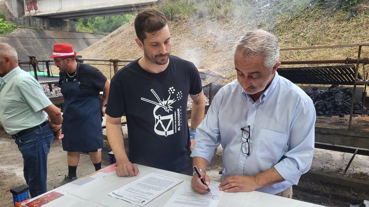 Alejandro Alonso, de la comisiónde festejos "El Salvador" de Perlora (Carreño), y el alcalde, Ángel García, durante la firma del acuerdo.