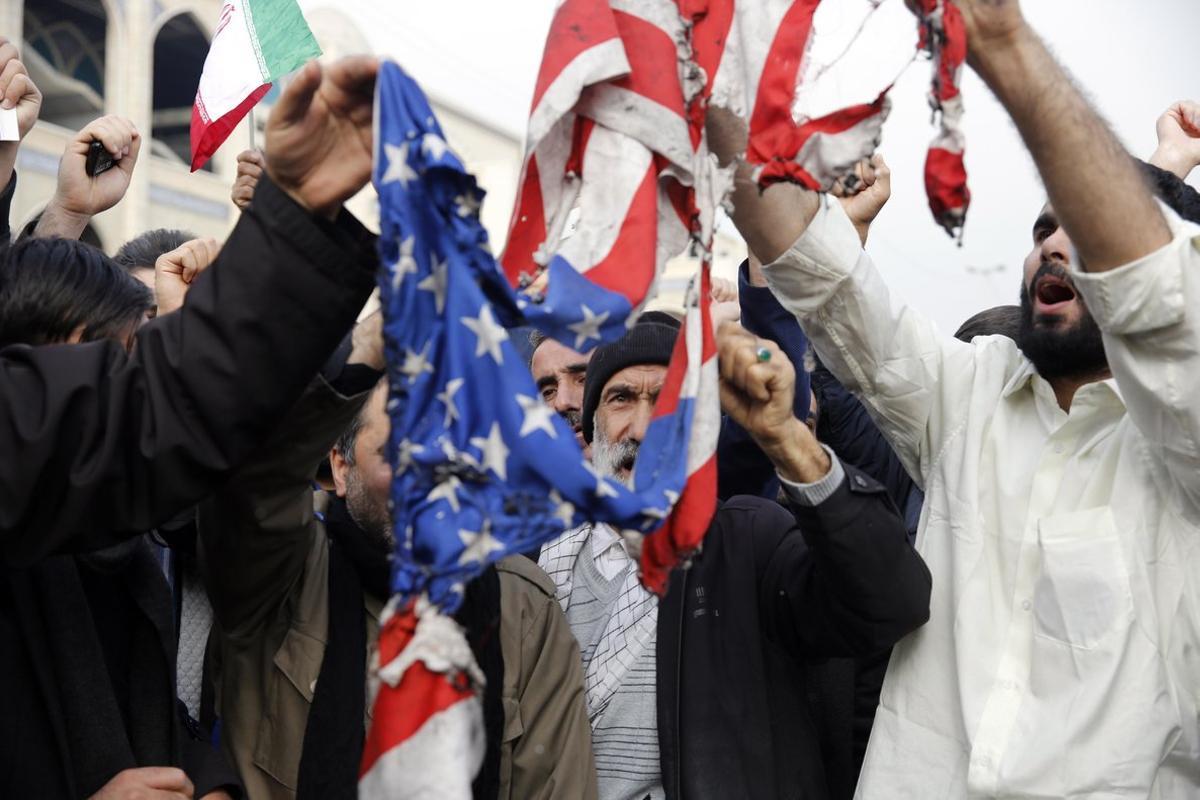 Tehran (Iran (islamic Republic Of)), 03/01/2020.- Iranians burn a US flag as thousands of people take to the streets to mourn the death of Iranian Revolutionary Guards Corps (IRGC) Lieutenant general and commander of the Quds Force Qasem Soleimani during an anti-US demonstration to condemn the killing of Soleimani, after Friday prayers in Tehran, Iran, 03 January 2020. The Pentagon announced that Iran’s Quds Force leader Qasem Soleimani and Iraqi militia commander Abu Mahdi al-Muhandis were killed on 03 January 2020 following a US airstrike at Baghdad’s international airport. The attack comes amid escalating tensions between Tehran and Washington. (Atentado, Estados Unidos, Bagdad, Teherán) EFE/EPA/ABEDIN TAHERKENAREH