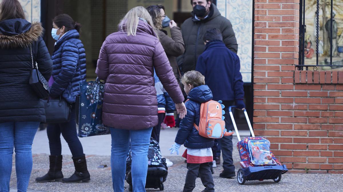 Archivo - Una madre deja a su hijo en la puerta del colegio.