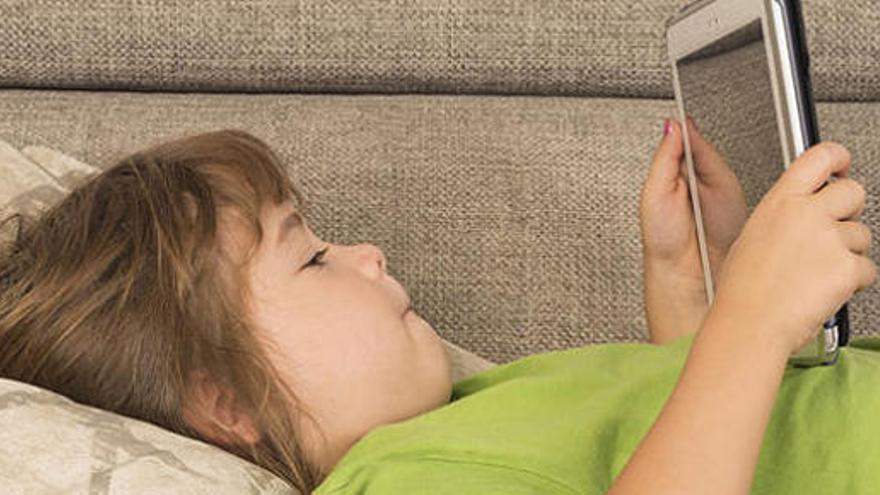 Una niña juega con una tablet.