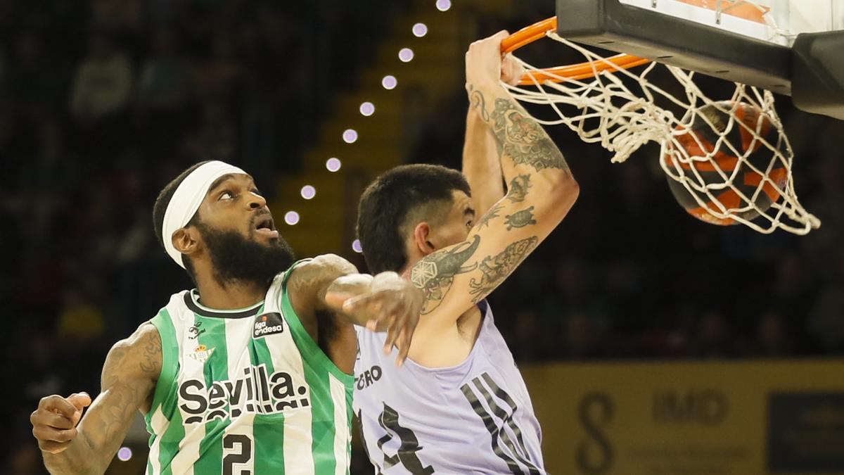 Gabriel Decks, del Real Madrid ejecuta un mate ante el jugador del Real Betis BJ Johnson del Betis durante el partido de la Liga Endesa.