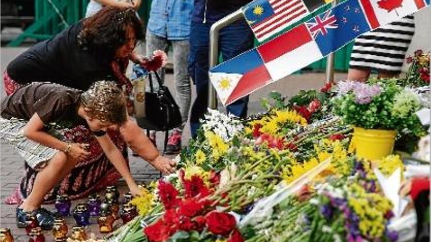 Nombroses persones dipositant flors en memòria de les víctimes del vol MH17 de Malaysia Airlines.