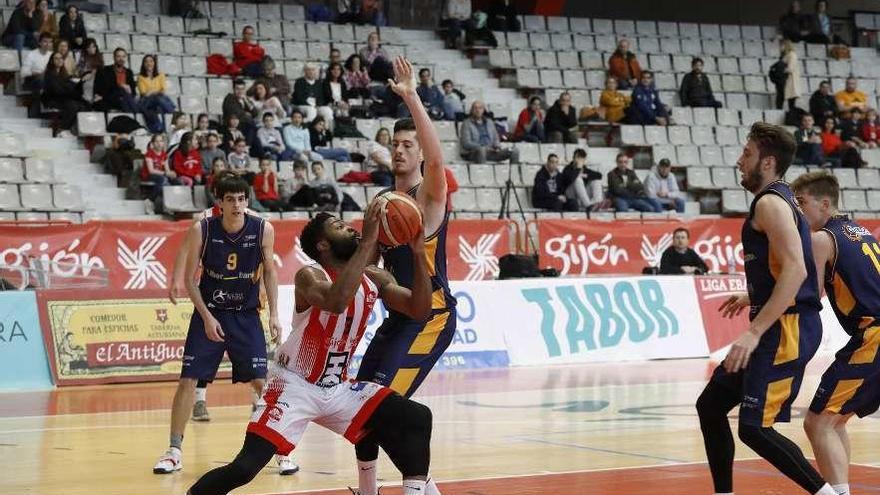 Kenny Ejim trata de superar en la zona a Felipe Braga.