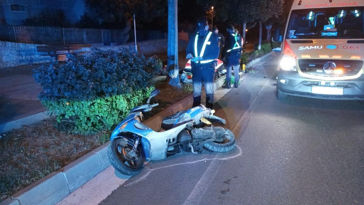 Un policía examina la moto en la que circulaba el hombre que falleció.