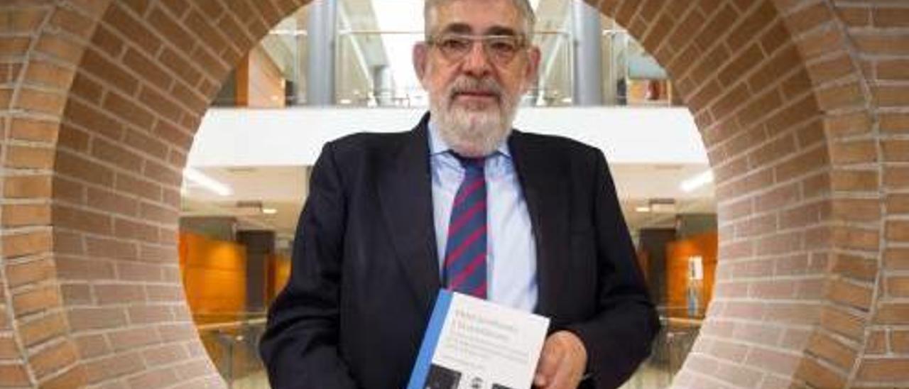 Vicente Navarro de Luján, con su libro, en la facultad del CEU-UCH en la que imparte clase.