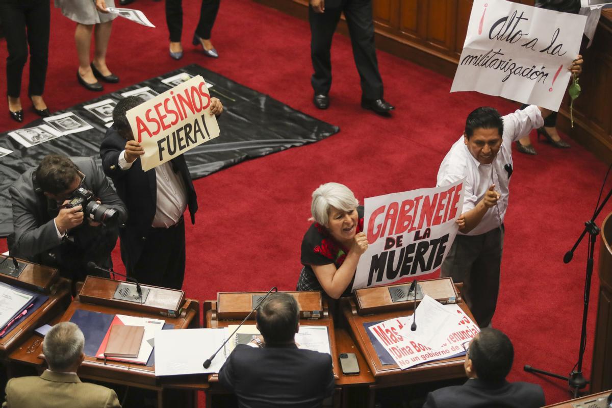 Miembros del Congreso sostienen pancartas mientras le gritan al primer ministro de Perú, Alberto Otarola, mientras él y su gabinete enfrentan un voto de confianza, en Lima (Perú).