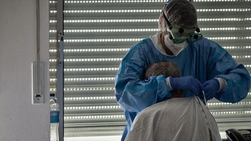 Un sanitario asiste a un enfermo de Covid-19 en el Hospital Universitario de Canarias.