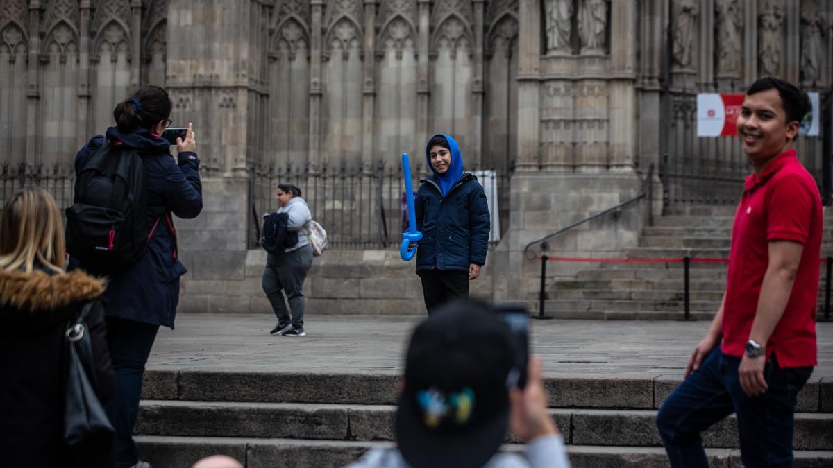 Unos turistas se fotografían delante de la Catedral de Barcelona.